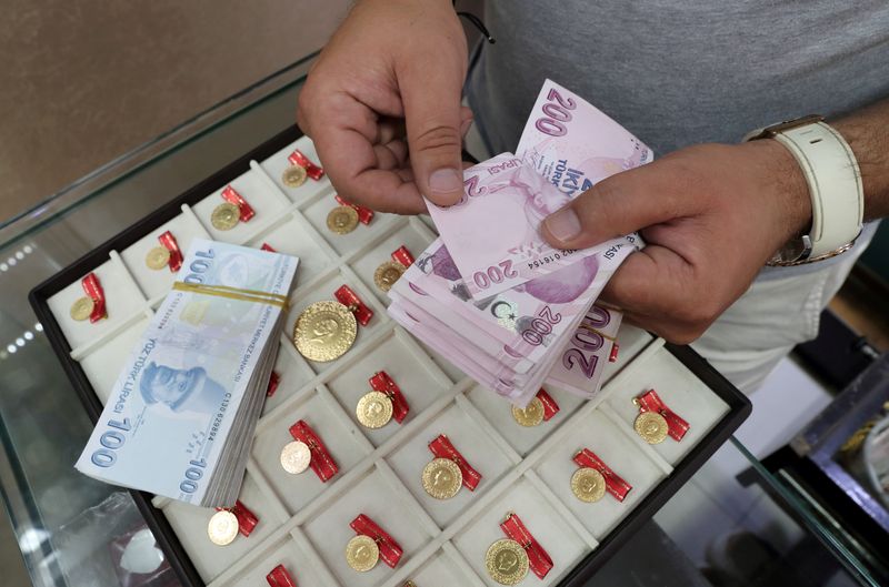 FILE PHOTO: FILE PHOTO: A gold dealer counts Turkish lira banknotes in Istanbul