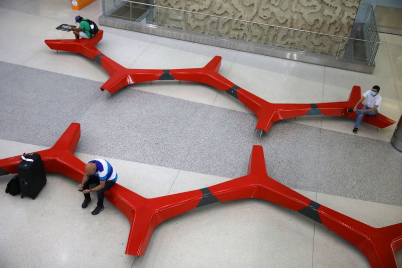 Passengers practice 'social distancing' at a main Miami International Airport terminal