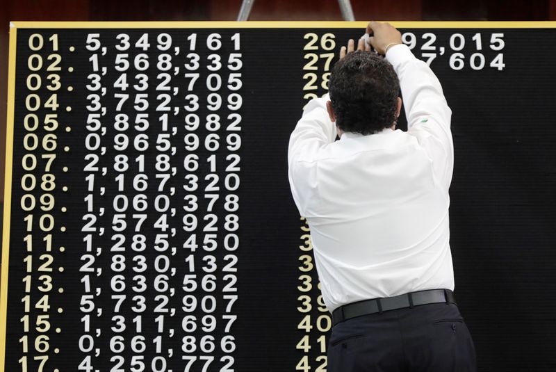 A man puts winning numbers on the board during a lottery raffle for the value of the last president's luxury plane at the National Lottery building in Mexico City