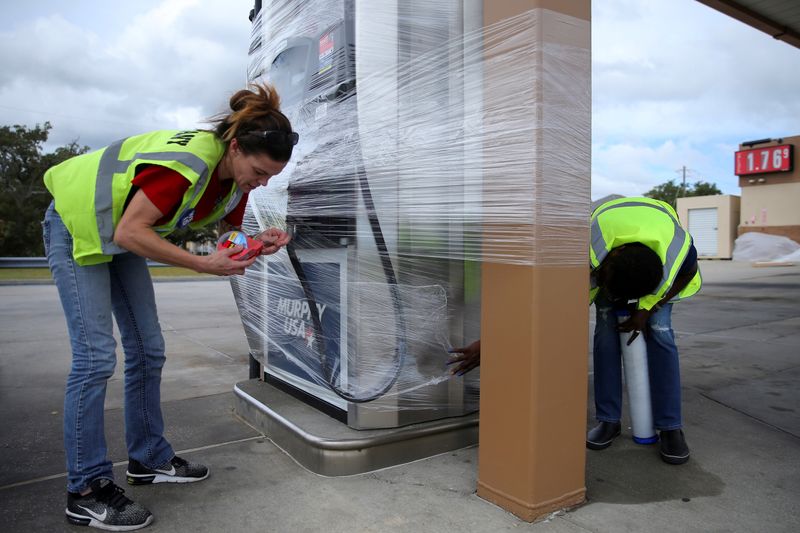 FILE PHOTO: Gas station attendants wrap pumps in plastic as Hurricane Sally approaches to Pass Christian