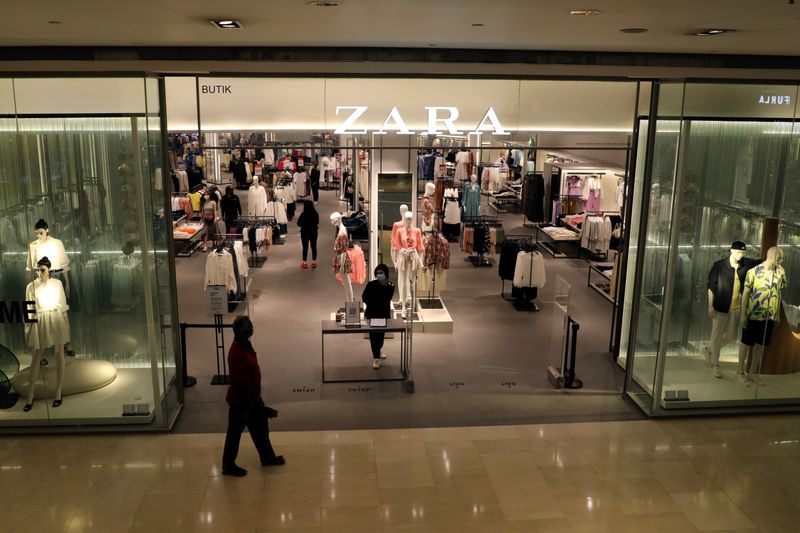 FILE PHOTO: Staff wearing protective mask waits for customers at the entrance of a Zara store, amid the coronavirus disease (COVID-19) outbreak in Kuala Lumpur
