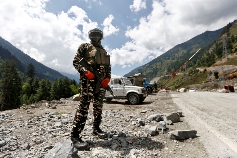 FILE PHOTO: An Indian Central Reserve Police Force personnel stands guard at a checkpoint along a highway leading to Ladakh, at Gagangeer