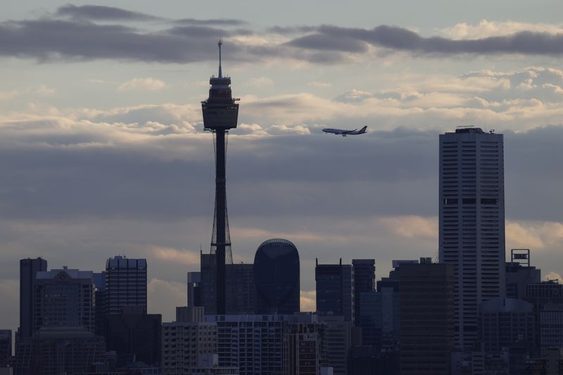 A Qantas plane flies over the city centre skyline in Sydney