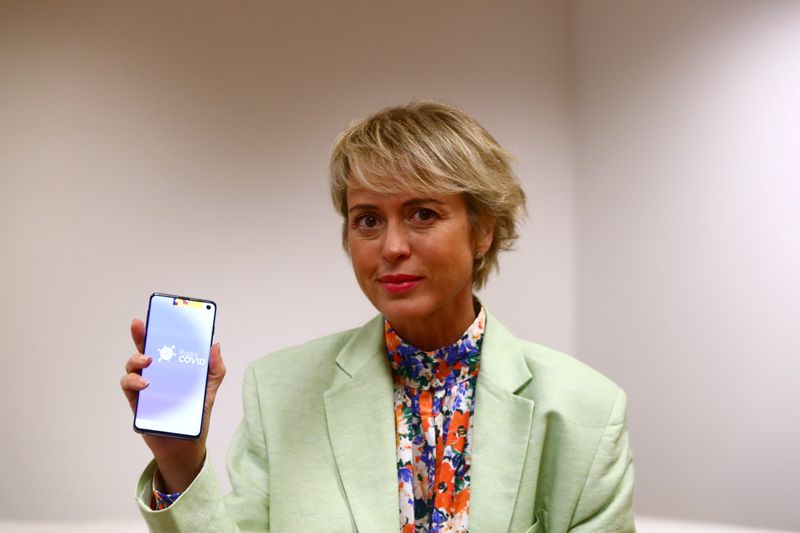 Artigas, head of Spain's state digital and artificial intelligence unit, poses holding a mobile phone with the Radar Covid app in Madrid