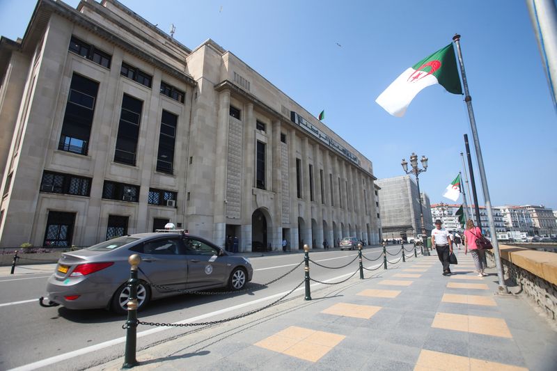 People walk past the building of the lower parliament chamber in Algiers