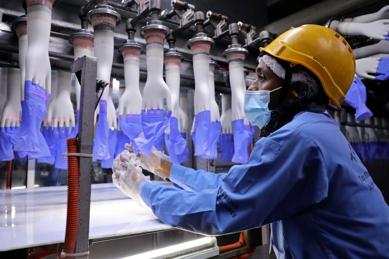 FILE PHOTO: A worker inspects newly-made gloves at Top Glove factory in Shah Alam
