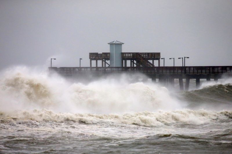 FILE PHOTO: Waves crash along a pier as Hurricane Sally approaches in Gulf Shores