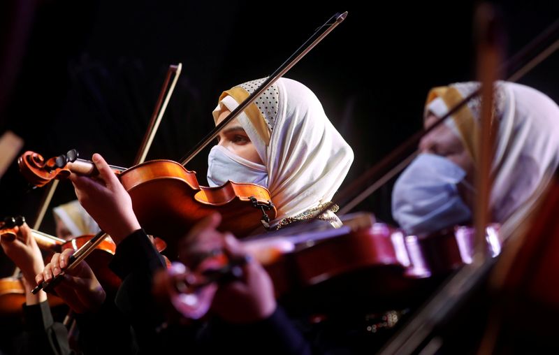 Members of Al-Nour Wal Amal (Light and Hope) chamber orchestra of blind women wearing protective masks play during their first concert at the Manasterly Palace in Cairo