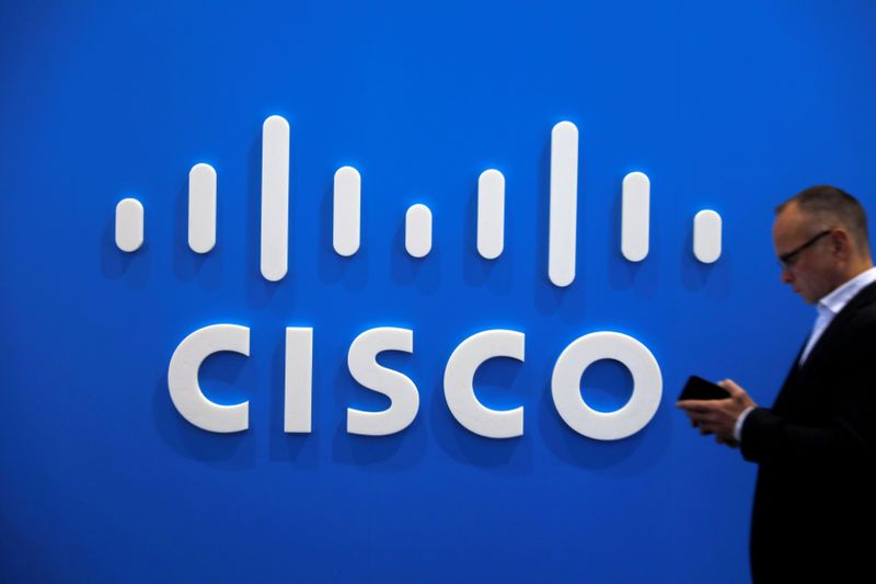 FILE PHOTO: A visitor uses a mobile phone in front of the Cisco booth at the Mobile World Congress in Barcelona