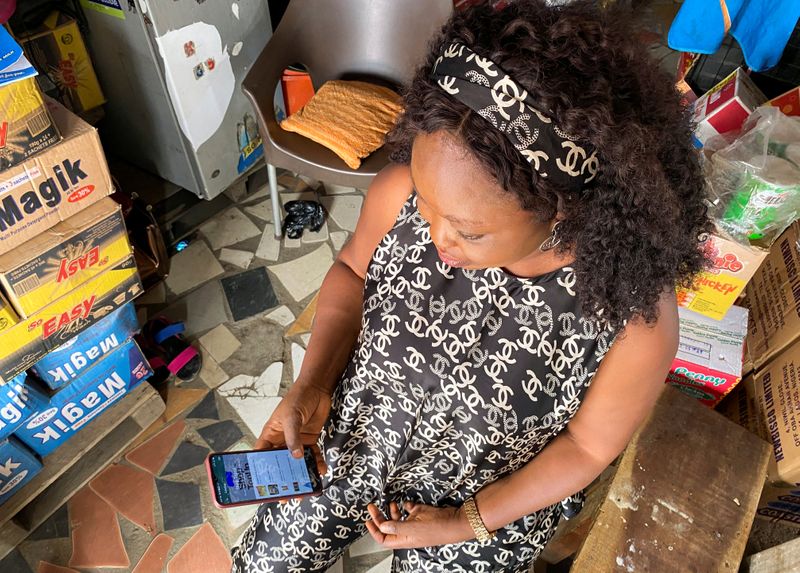 Kiosk store owner, Funmilayo Akinola, uses Trade Depot company's app inside her store in Lagos