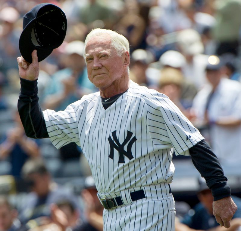 Hall of Famer Whitey Ford tips his cap as he runs onto the field during introductions for the 65th Old Timers' Day game in New York