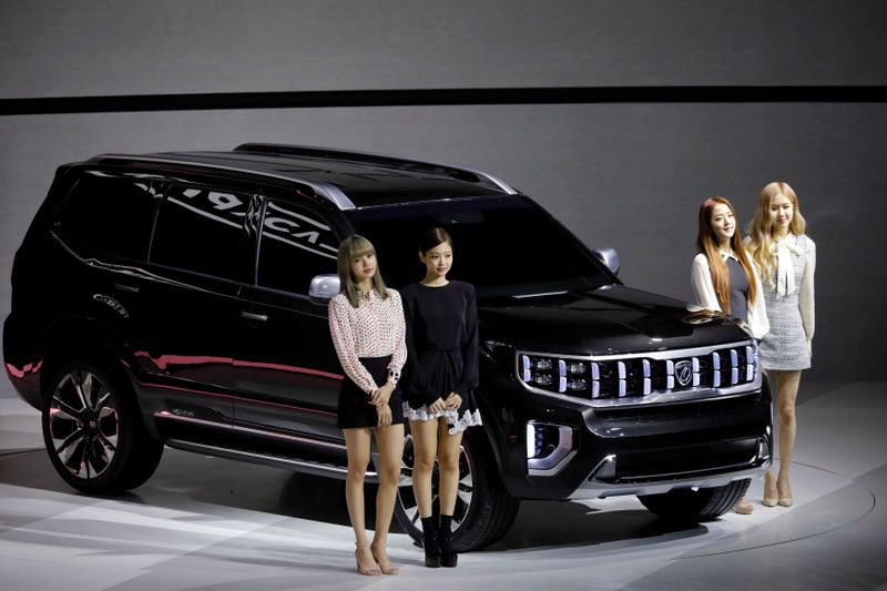Members of K-pop idol group Black Pink pose for photographs with Kia Motors' Mohave during the 2019 Seoul Motor Show in Goyang