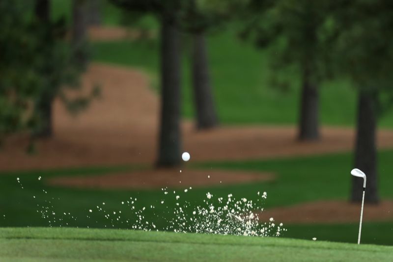 FILE PHOTO: Marc Leishman of Australia hits from a sand trap on the seventh hole during third round play of the 2018 Masters golf tournament in Augusta