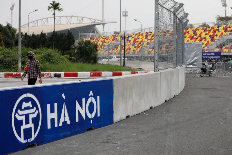 FILE PHOTO: A man wears a protective mask as he guards at the construction site of Formula One Vietnam Grand Prix racing track in Hanoi