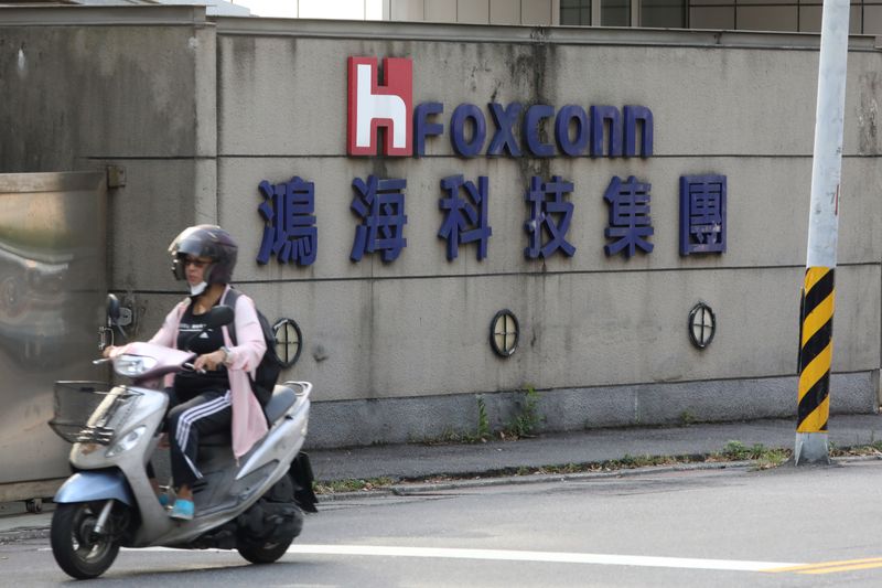 A person riding a scooter wears a mask amid the outbreak of the coronavirus disease (COVID-19), while passing a Foxconn office building in Taipei