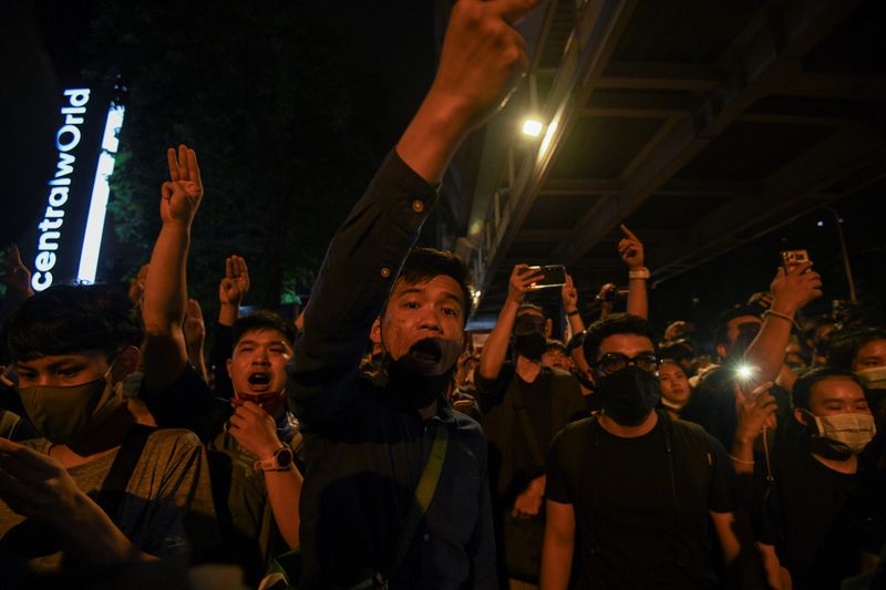 People show the three-finger salute during a gathering of pro-democracy protesters who demand the government to resign and to release detained leaders in Bangkok