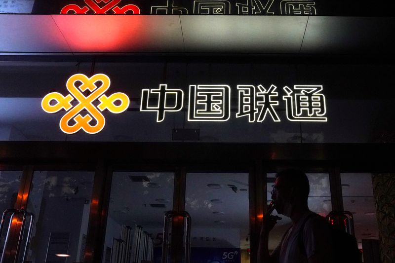 Man smokes in front of a China Unicom store in Beijing