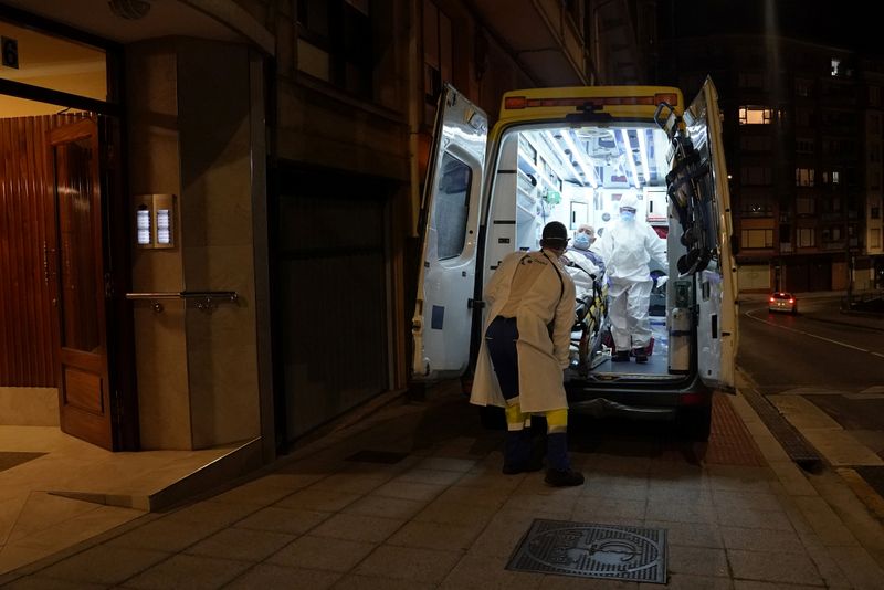 Ambuiberica medical staff members lift a suspected coronavirus disease (COVID-19) patient into an ambulance, in the Basque port town of Bermeo