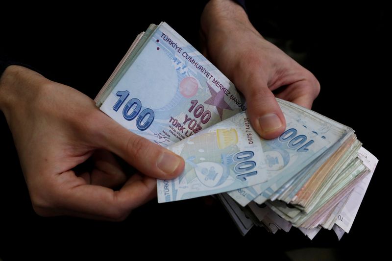 FILE PHOTO: A merchant counts Turkish lira banknotes at the Grand Bazaar in Istanbul, Turkey
