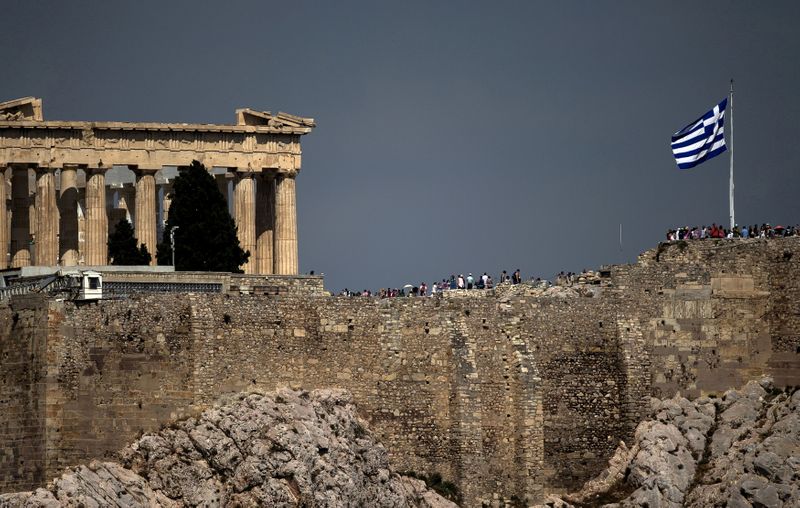 FILE PHOTO: Greek flag flutters in front of the ancient Parthenon temple atop the Acropolis hill archaeological site in Athens