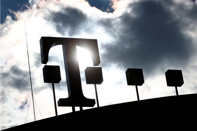 FILE PHOTO: Logo of Deutsche Telekom AG is silhouetted atop of the headquarters of the German telecommunications giant in Bonn
