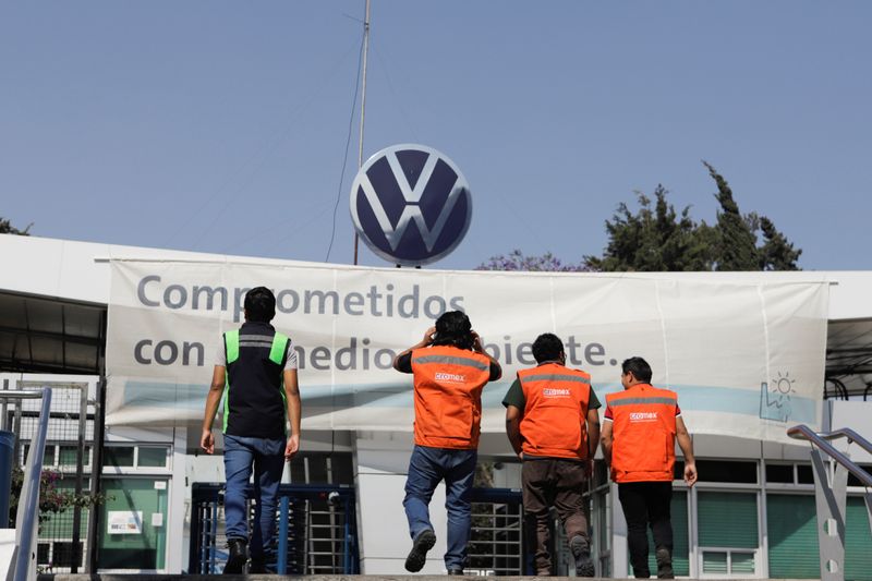 Workers walk outside the Volkswagen (VW) plant as the company will temporarily close its factories in Mexico amid growing worries over the spread of the coronavirus disease (COVID-19), in Puebla