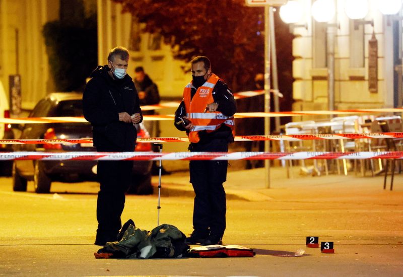 Police officers survey the site of a shooting in Biel