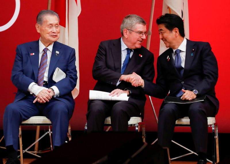FILE PHOTO: IOC President Bach shakes hands with Japan's PM Abe during the 'One Year to Go' ceremony celebrating one year out from the start of the summer games in Tokyo
