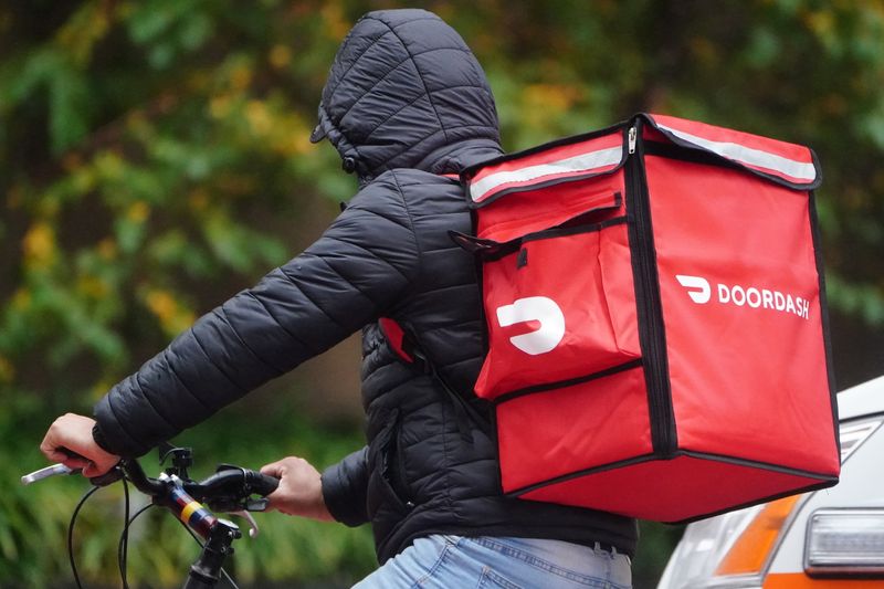 A delivery person for Doordash rides his bike in the rain during the coronavirus disease (COVID-19) pandemic in the Manhattan borough of New York City