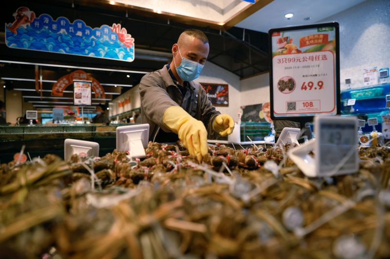 A staff member lays out seafood at a supermarket in Beijing