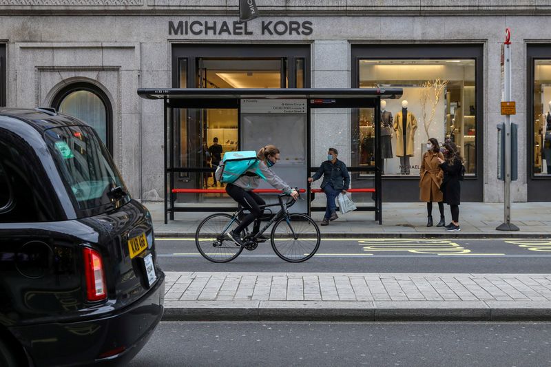 FILE PHOTO: A taxi passes as people wait at a bus stop in Regent Street, London, Britain