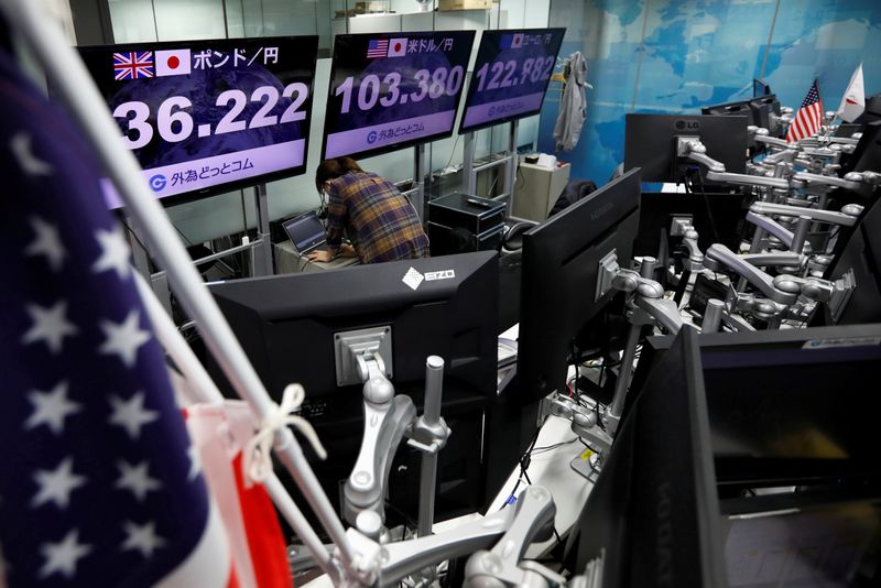 FILE PHOTO: An employee of the foreign exchange trading company works in front of monitors showing the Japanese yen exchange rate against foreign currencies at a dealing room in Tokyo