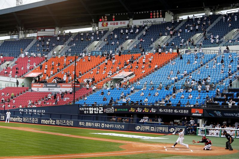 Socially-distanced fans wearing face masks as a measure to avoid the spread of the coronavirus disease (COVID-19), watch a KBO baseball game between LG Twins and Doosan Bears at a baseball stadium in Seoul