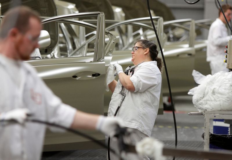 An employee works on the sealer line in the paint department during a tour of an automobile plant in Marysville