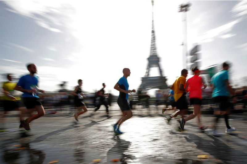 Runners make their way past the Eiffel Tower as they participate in the 42nd Paris Marathon