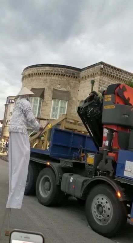 Performers on stilts are seen next to a vehicle transporting the statue of British Admiral Lord Horatio Nelson during its send-off in this still picture obtained from social media video dated November 16, 2020, in Bridgetown, Barbados