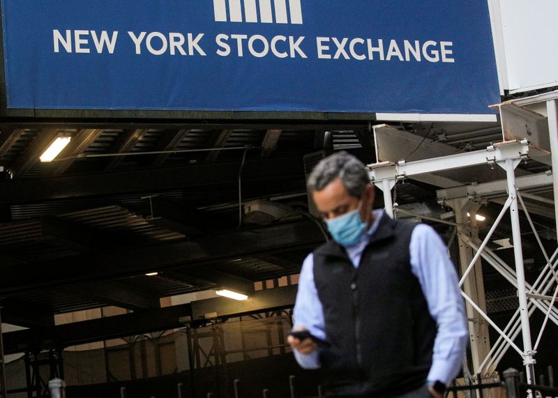 A New York Stock Exchange employee uses his phone on Wall St. outside the NYSE in New York