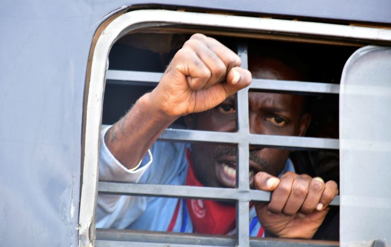 Ugandan presidential candidate Robert Kyagulanyi reacts from inside a police van, in Luuka district