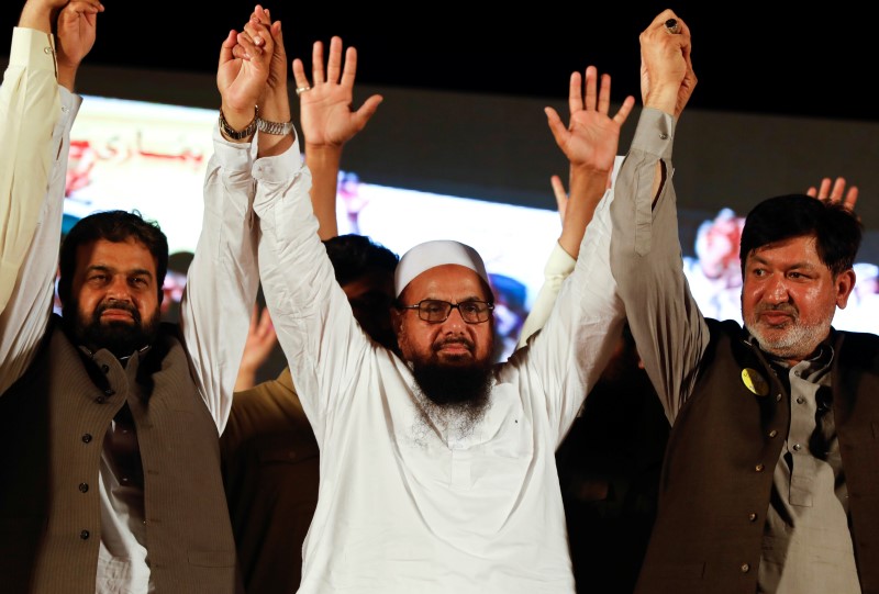 Hafiz Muhammad Saeed (C), chief of the Islamic charity organisation Jamaat-ud-Dawa (JuD), joins hands with Saeed Ahmed Gujar (R) nominated candidate of political party, Milli Muslim League (MML), as he attend a campaign rally,in Islamabad