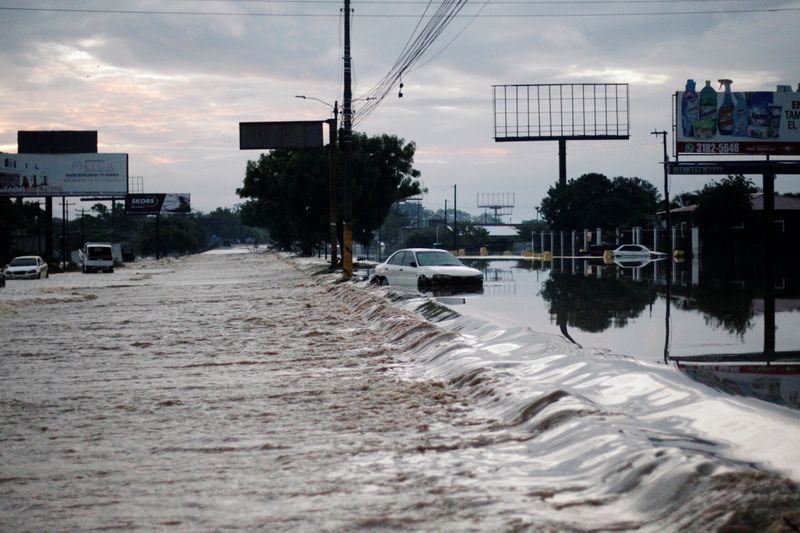 A stranded car is seen at a road flooded by the Chamelecon River due to heavy rain caused by Storm Iota, in La Lima