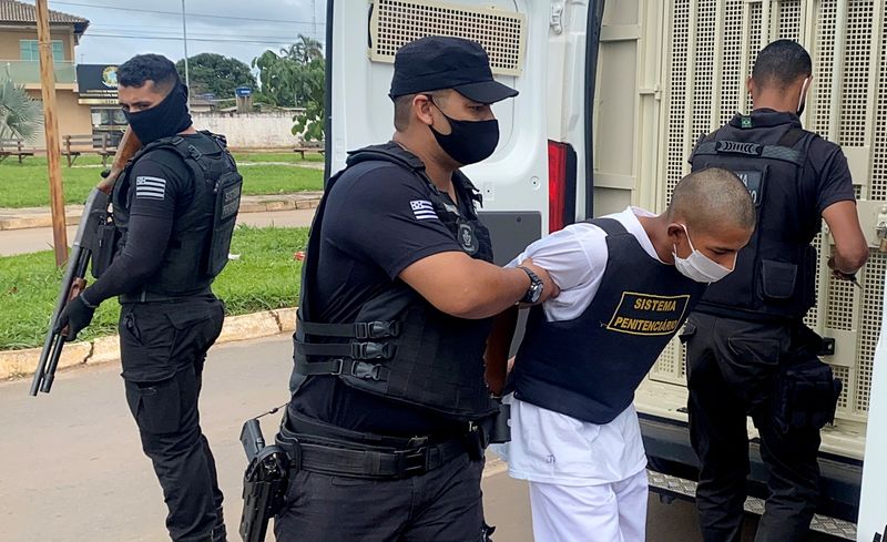 Costa, who confessed to killing Japanese woman Hitomi Akamatsu is escorted by a police officer in Abadiania
