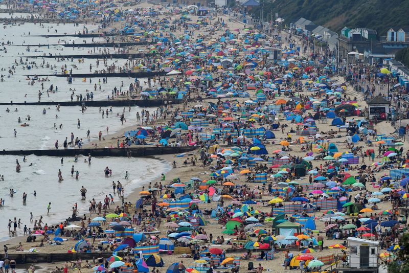 FILE PHOTO: People enjoy the sunny weather at the Bournemouth Beach, amid the coronavirus disease (COVID-19) outbreak, in Bournemouth