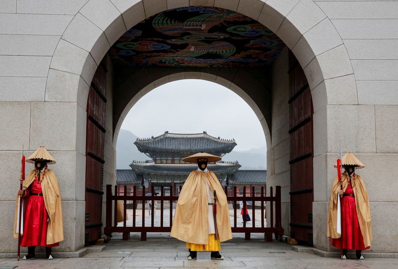 Workers wearing traditional attire wear masks to prevent the spread of the coronavirus disease (COVID-19) during the daily re-enactment of the changing of the Royal Guards at Gyeongbok Palace in central Seoul