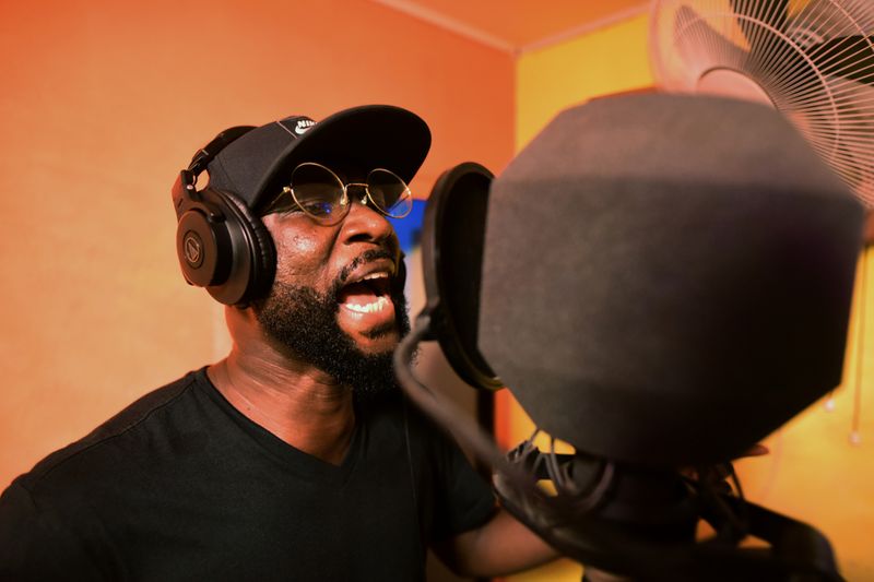 Sierra Leonean musician Emmerson Bockarie sings into a microphone while recording a song at a studio in Freetown,