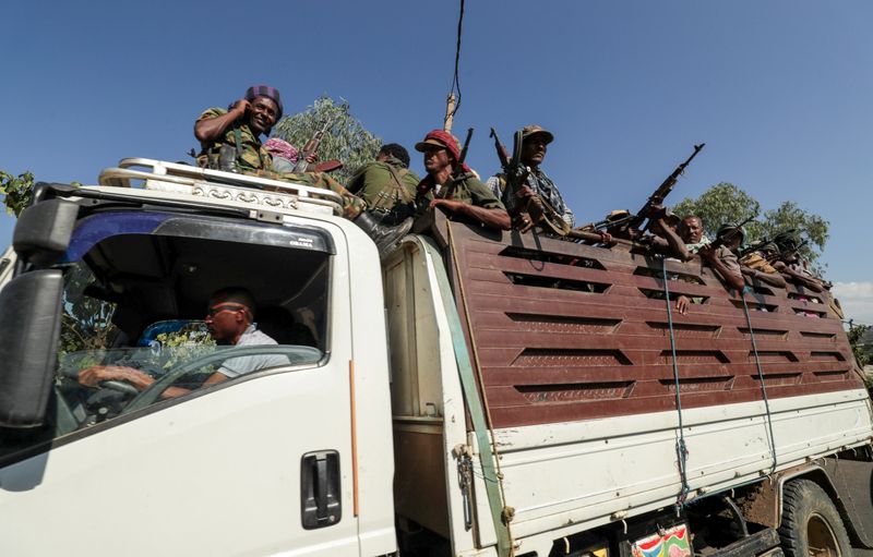 FILE PHOTO: Members of Amhara region militias ride on their truck as they head to face the Tigray People's Liberation Front in Sanja