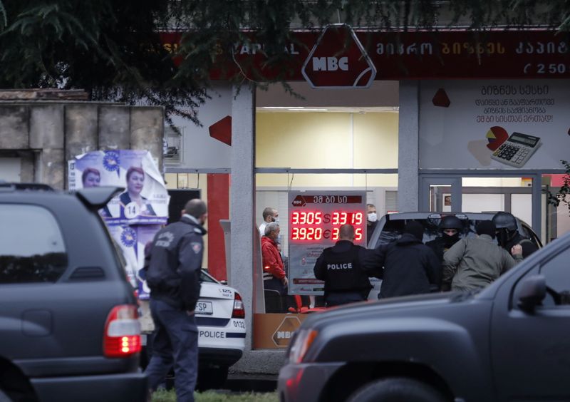 Law enforcement officers gather in a street near an office of a microfinance organisation after an unidentified gunman took hostages, in Tbilisi