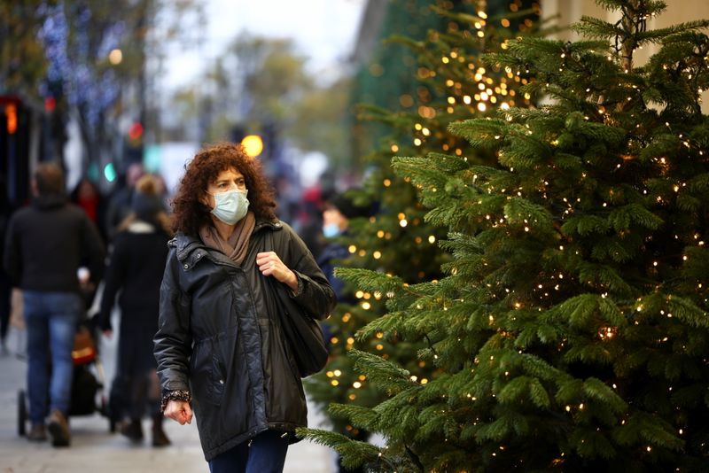A woman walks past Christmas trees on Oxford Street, amid the coronavirus disease (COVID-19) outbreak, in London