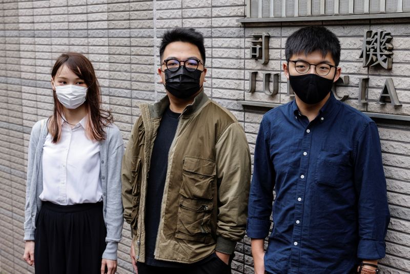 Pro-democracy activists Ivan Lam, Joshua Wong and Agnes Chow arrive at the West Kowloon Magistrates' Courts to face charges related to illegal assembly stemming from 2019, in Hong Kong