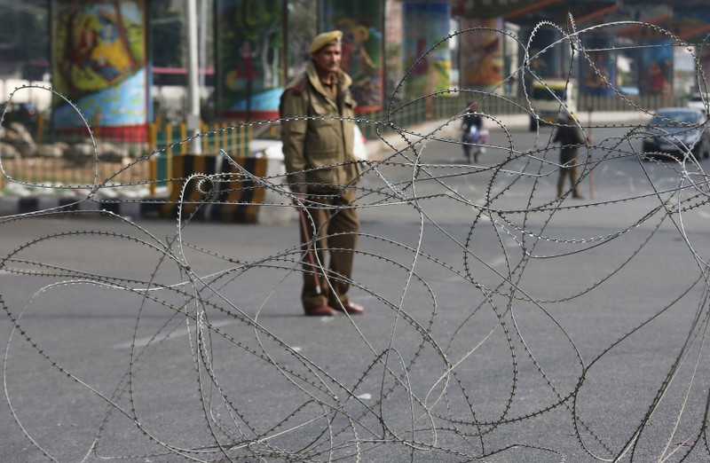 A policeman stands guard at a street during a curfew in Jammu