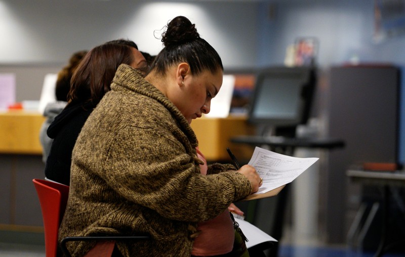A job seeker fills out an application at a job fair at the Denver Workforce Center in Denver